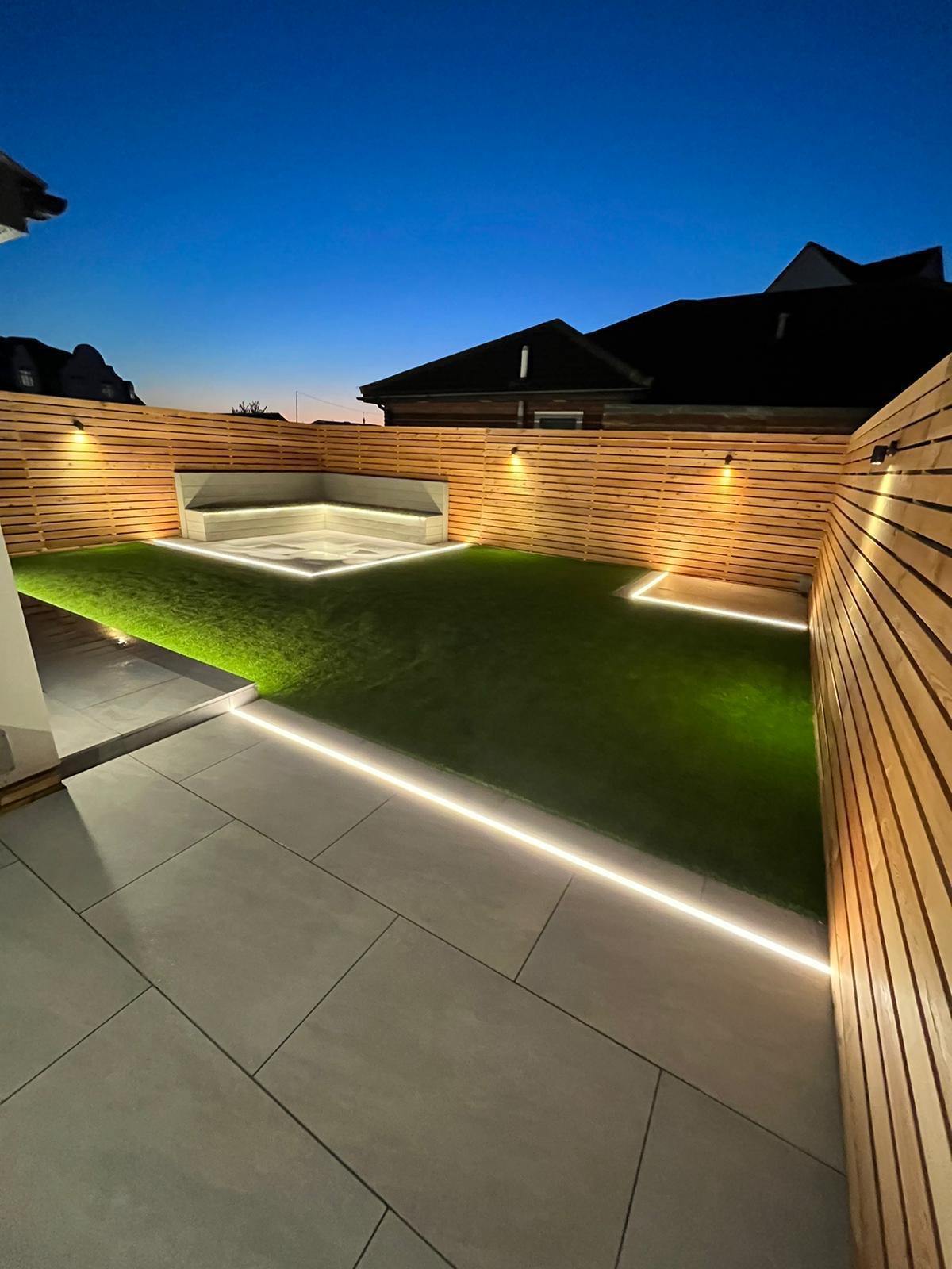 Contemporary garden at dusk with cedar slatted fencing and integrated LED strip lighting